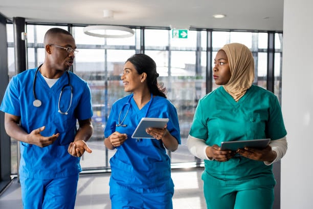 2 Doctors and a Nurse Walking and Holding Clipboards